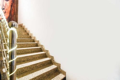 a staircase with a saxophone next to a wall at Hotel O Hirak Road Dhanbad in Dhanbād