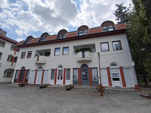 un gran edificio blanco con puertas y ventanas rojas en City Lights Apartman, en Keszthely