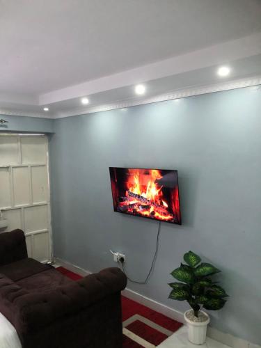 a living room with a fireplace on the wall at Bright Serene Studio Bnb in Nairobi