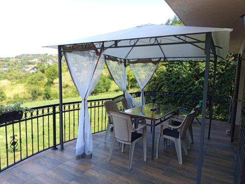 a table and chairs under an umbrella on a deck at Holiday Home Dzeni in Zenica