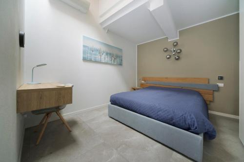 a bedroom with a bed and a desk and a bed sidx sidx sidx at Appartamento tra Muretto e Budello con posto auto in Alassio