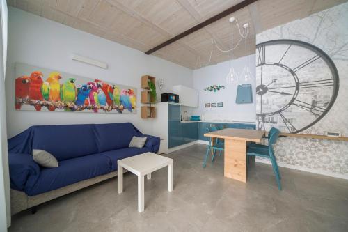 a living room with a blue couch and a table at Appartamento tra Muretto e Budello con posto auto in Alassio