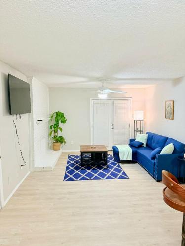 a living room with a blue couch and a table at Central 1BR Retreat by Hospital and tollway in Addison
