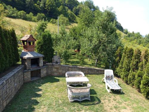 two chairs and a table in a yard with a fireplace at Holiday Home Dzeni in Zenica