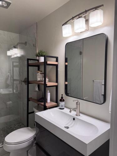 ein Badezimmer mit Waschbecken, Toilette und Spiegel in der Unterkunft Modern Studio 65 TV, King Bed, Hot Tub in Park City