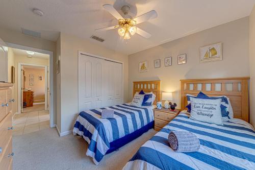 a bedroom with two beds and a ceiling fan at Sunset Dreams Villa, Beautiful 4 Bedroom Villa with Private Pool Near Disney 422 in Orlando