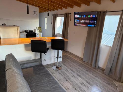 une cuisine avec un comptoir et un bar avec deux chaises dans l'établissement Departamento Colonos Galeses, à Puerto Madryn