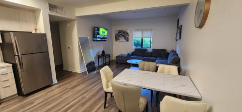 a kitchen and living room with a table and a couch at Disney Vacay 8 min Away in Irvine