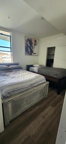 a bedroom with two beds and a mirror at Disney Vacay 8 min Away in Irvine