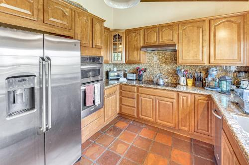 a kitchen with wooden cabinets and a stainless steel refrigerator at Stunning Valley and Mtn Views Elegant Temecula Home in Temecula