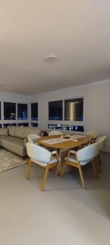 a living room with a wooden table and a couch at Mirante da barra in Tramandaí
