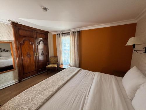 a bedroom with a white bed and a window at Hacienda San Angel in Ensenada