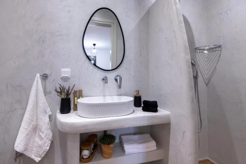a white bathroom with a sink and a mirror at Aphrodite's Refuge in Galissas