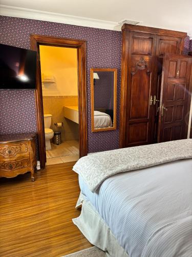 a bedroom with a bed and a mirror and a bathroom at Hacienda San Angel in Ensenada