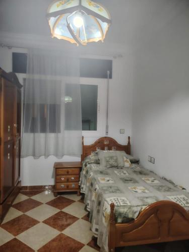 a bedroom with a bed and a chandelier at Hybrid appartment in Ouedlaou in Oued Laou