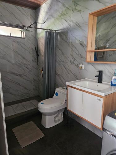 a bathroom with a toilet and a sink at Paso de las Lapas in Uvita