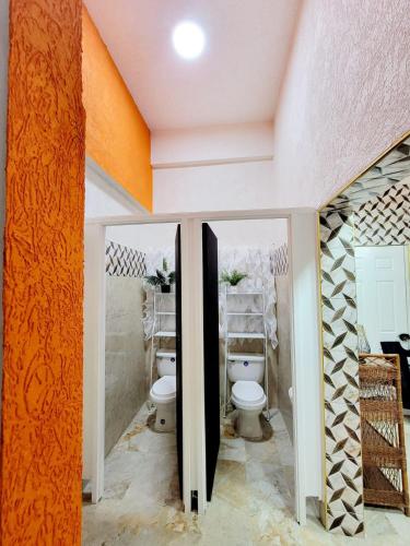 a bathroom with a toilet and two mirrors at Kingston Manor Vacation Homes in Kingston