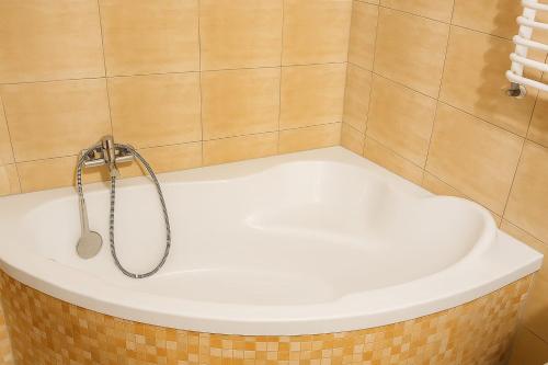 a bath tub with a shower in a bathroom at Apartament Marzenie in Kowary