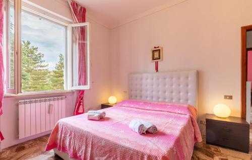 a bedroom with a pink bed with two towels on it at Awesome Home In Capolona in Capolona
