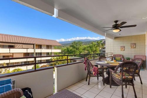 a patio with a table and chairs on a balcony at Beachside Condo with Ocean Views in Kailua-Kona