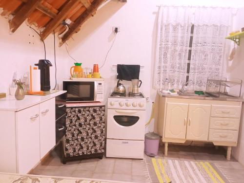 a kitchen with a stove and a microwave at Chalezinho da Serra in Natividade da Serra