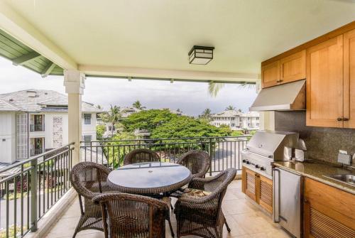 a kitchen with a table and chairs on a balcony at Kolea 14F - Heated Pool Gym & More in Waikoloa