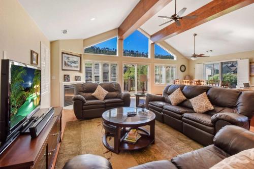 a living room with leather furniture and a flat screen tv at Mule Meadows - Classy Split level South Tahoe home in South Lake Tahoe
