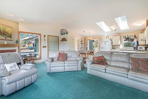 a living room with white couches and a kitchen at Elk Forest Escape - Economy Family Abode in South Lake Tahoe