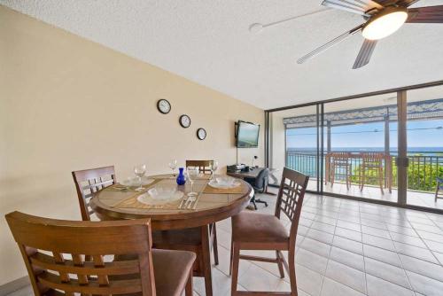 a dining room with a table and a view of the ocean at Kona Alii - Oceanview Pool Shops & Restaurants in Kailua-Kona