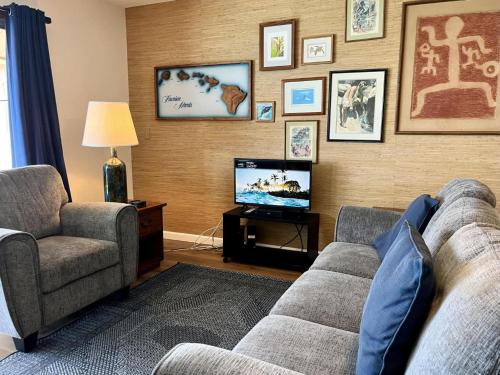a living room with a couch and a tv at Oceanfront Vintage Retreat in Kailua-Kona in Kailua-Kona