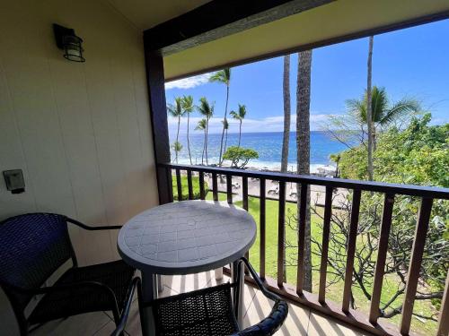 a balcony with a table and chairs and a view of the ocean at Kona Isle Oceanfront Condo in Kailua-Kona