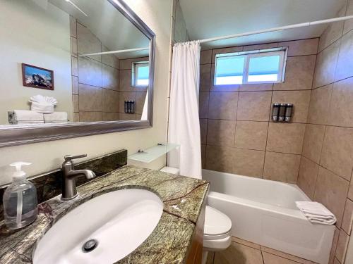 a bathroom with a sink and a tub and a toilet at Kona Isle Oceanfront Condo in Kailua-Kona