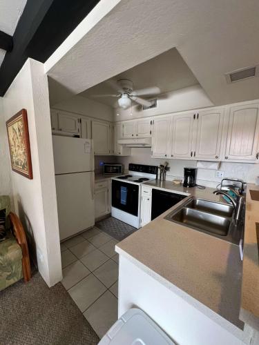 a kitchen with white cabinets and a sink at Casa De Emdeko Condo with Pool AC & Ocean Views in Kailua-Kona