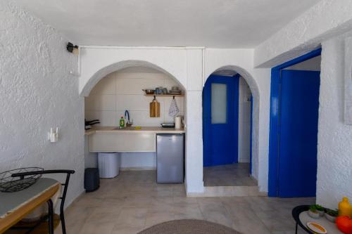 a kitchen with blue doors and a white wall at Phone Booth in Koutsounari