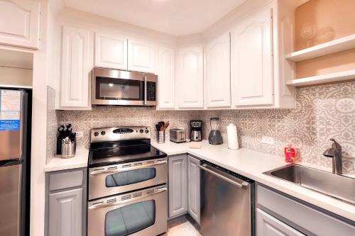 een keuken met witte kasten en roestvrijstalen apparaten bij Lakeland Getaway - Walk to Lake in South Lake Tahoe