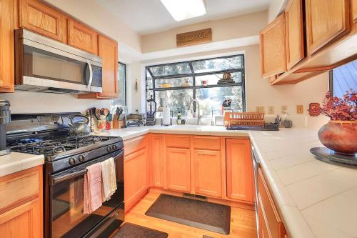 a kitchen with wooden cabinets and a stove and a window at Tahoe Family Getaway in Stateline