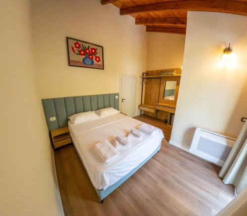 a bedroom with a bed with white sheets and pillows at Sofra Kelmendit in Tamarë