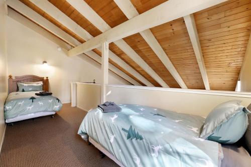 a bedroom with two beds and a wooden ceiling at Lakeland Sandy Beach Retreat - Private Escape in South Lake Tahoe