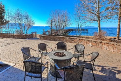 a group of chairs sitting around a table with the water at Lakeland Sandy Beach Retreat - Private Escape in South Lake Tahoe
