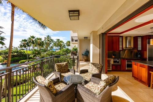 a balcony with a table and chairs and a kitchen at Gorgeous Villa in Ko Olina in Kapolei