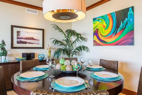 a dining room with a table with chairs and a painting at Beachfront Condo in Ko Olina Paradise in Kapolei