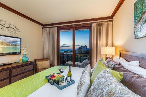 a bedroom with a bed with a table and a television at Beachfront Condo in Ko Olina Paradise in Kapolei