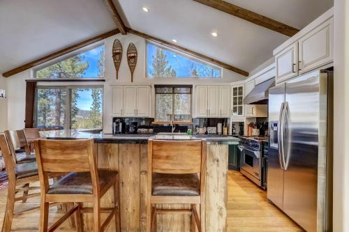 a kitchen with a center island with two wooden chairs at Luxe Mountain Chalet - Hot tub Man Cave Foosball Peloton in South Lake Tahoe