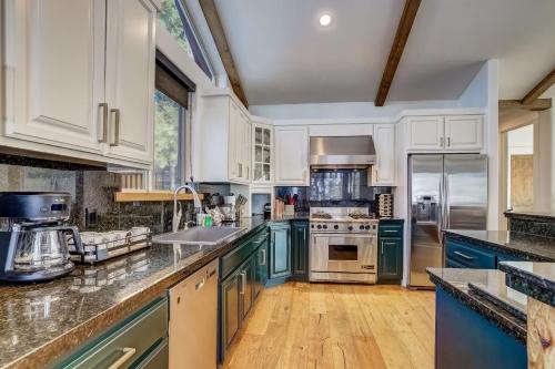 a kitchen with white cabinets and blue appliances at Luxe Mountain Chalet - Hot tub Man Cave Foosball Peloton in South Lake Tahoe