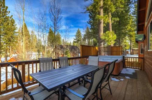 a wooden deck with a wooden table and chairs at Luxe Mountain Chalet - Hot tub Man Cave Foosball Peloton in South Lake Tahoe