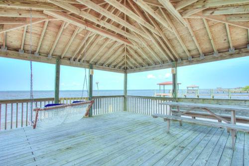 a wooden deck with a swing on the beach at 2015 - Makai in Sanderling