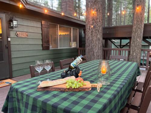 Una mesa verde y blanca con copas de vino y comida sobre ella. en Come Snuggle Up at Cozy Bear Cabin, en South Lake Tahoe