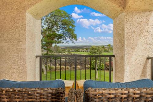 uitzicht vanaf een balkon met twee stoelen en een raam bij Golf Course Townhome in Waikoloa Beach in Waikoloa