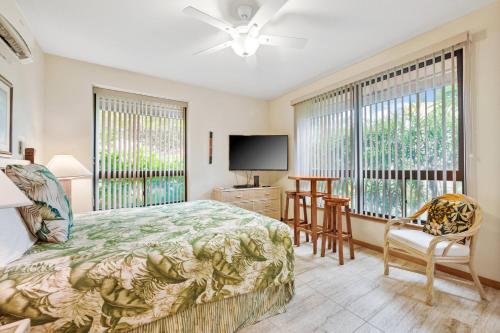 a bedroom with a bed and a flat screen tv at Romantic Studio in Waikoloa Beach Resort in Waikoloa