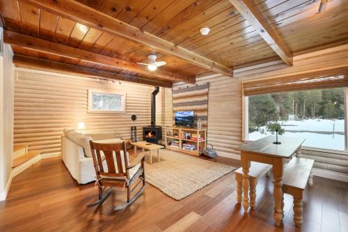 a living room with a table and a fireplace at Augies Authentic Log Cabin Pets Welcome in South Lake Tahoe